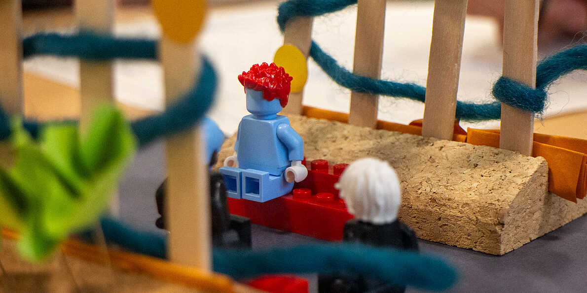 Eine Lego-Figur sitzt auf einem Modell.