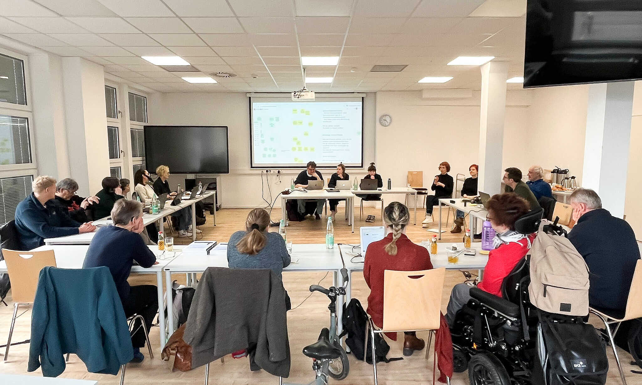 Teilnehmende des Workshops sitzen in einer großen Runde zusammen.